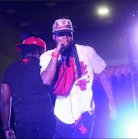 a man in a red hat is singing into a microphone